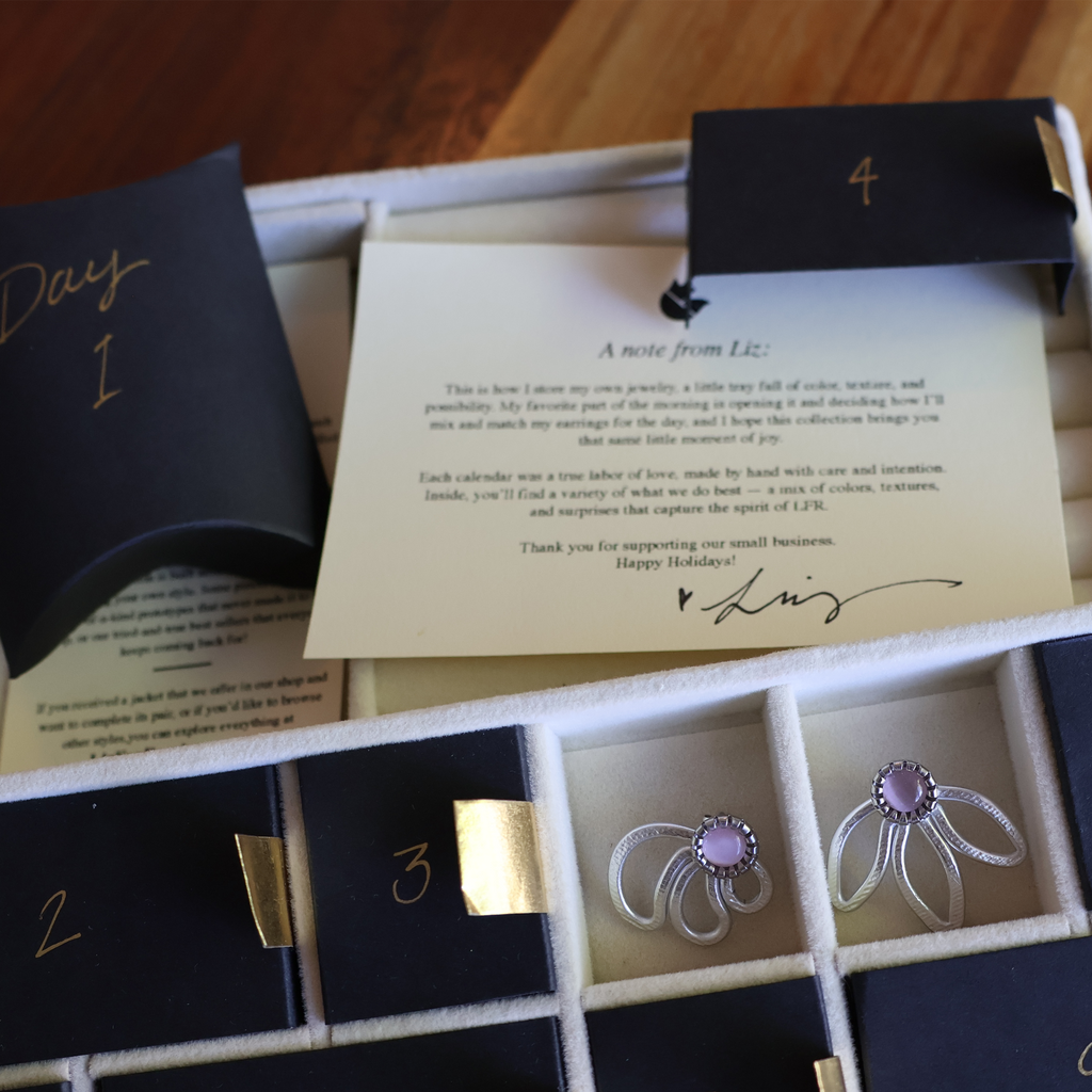 Jewelry set with earrings and a card in an open box on a wooden surface