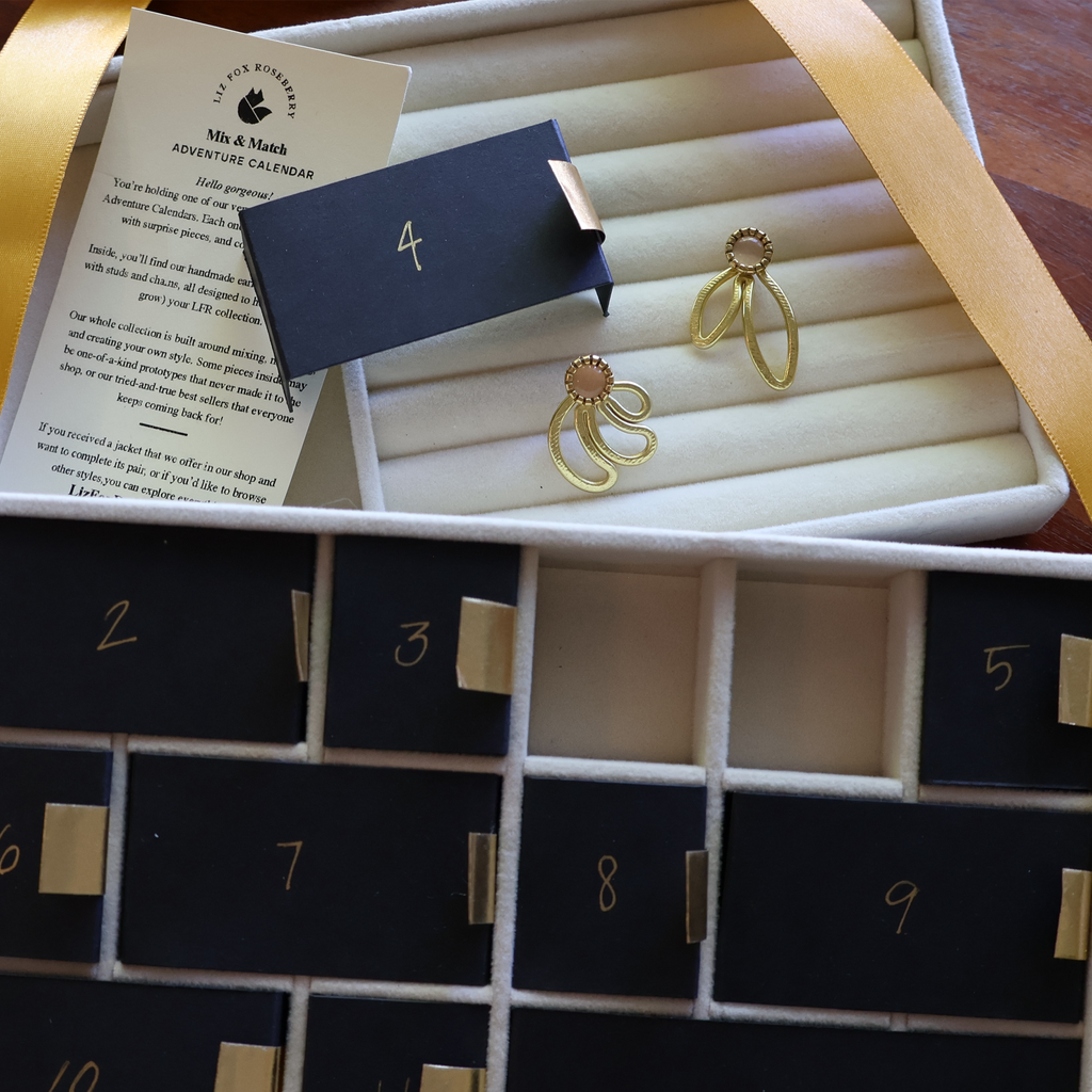 Gold earrings in a jewelry box with an advent calendar