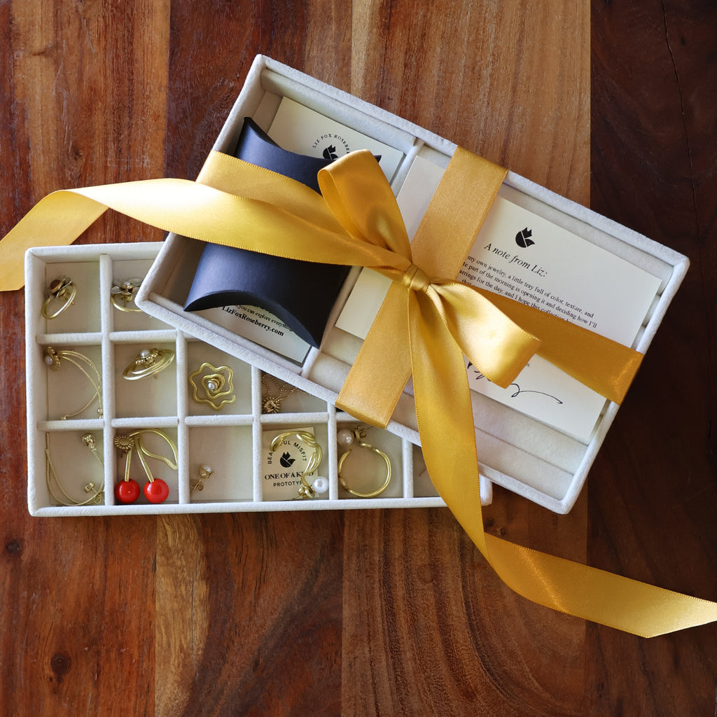 Jewelry set with yellow ribbon in a box on a wooden surface